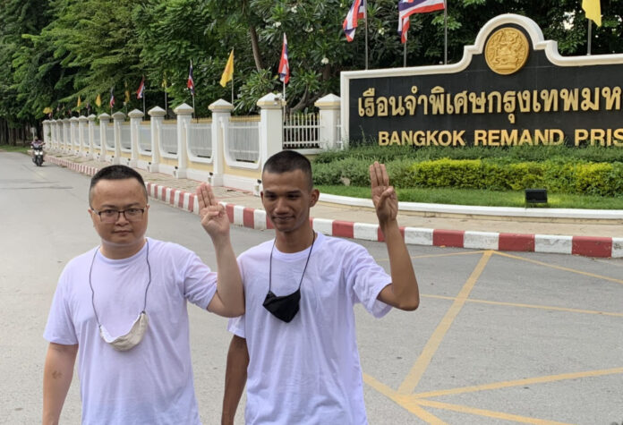 Arnon Nampha and Panupong Jadnok hold up three fingers after their release from Bangkok Remand Prison on Sept. 7, 2020.