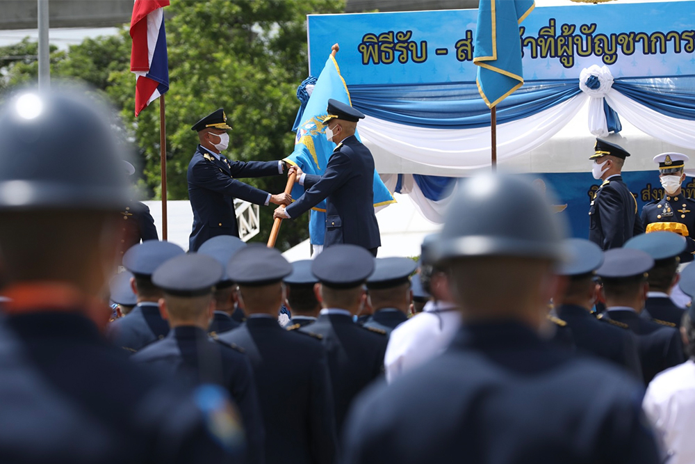 Former air force chief Gen. Manaat Wongwat hands the flag of the commander-in-chief of the air force to his successor, Gen. Airbull Suttiwan.