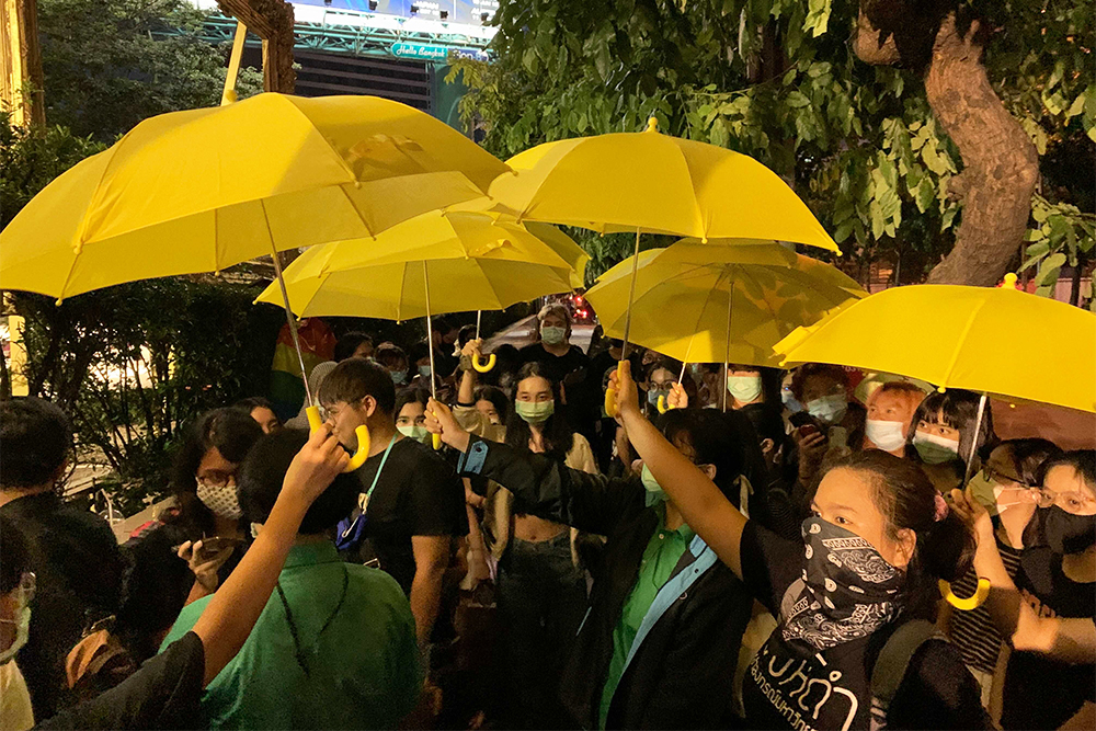 Protesters hold yellow umbrellas in a reference to the protest in Hong Kong.