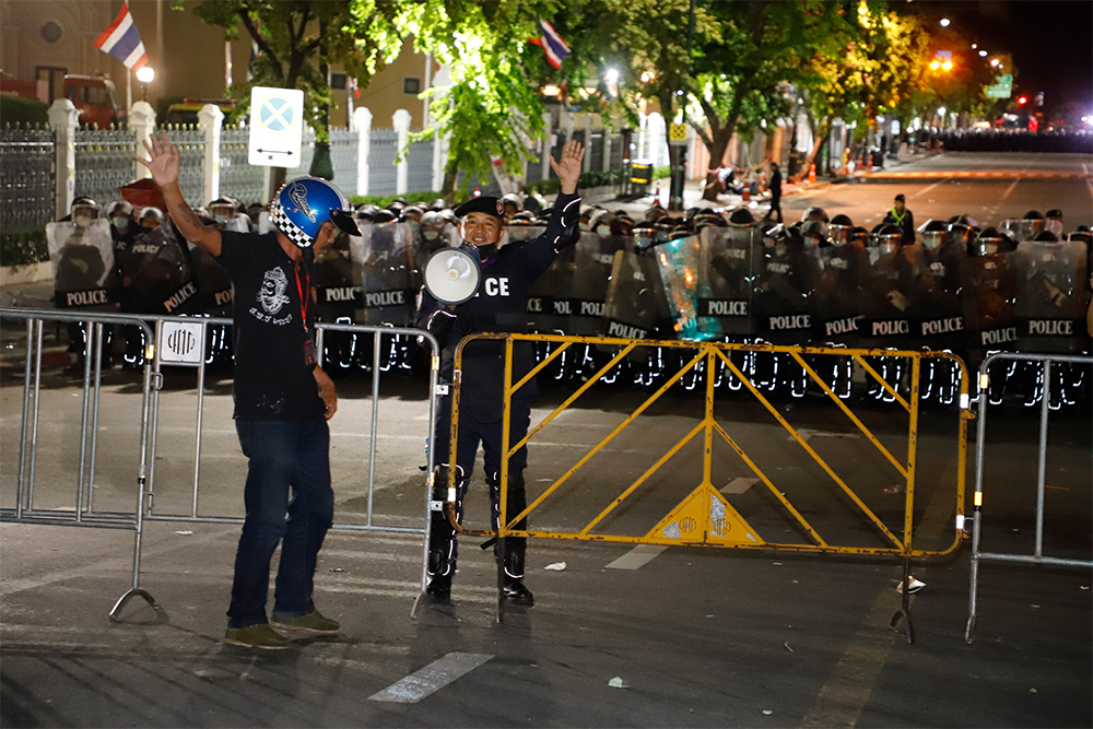 A police officer instructs protesters to vacate the area.