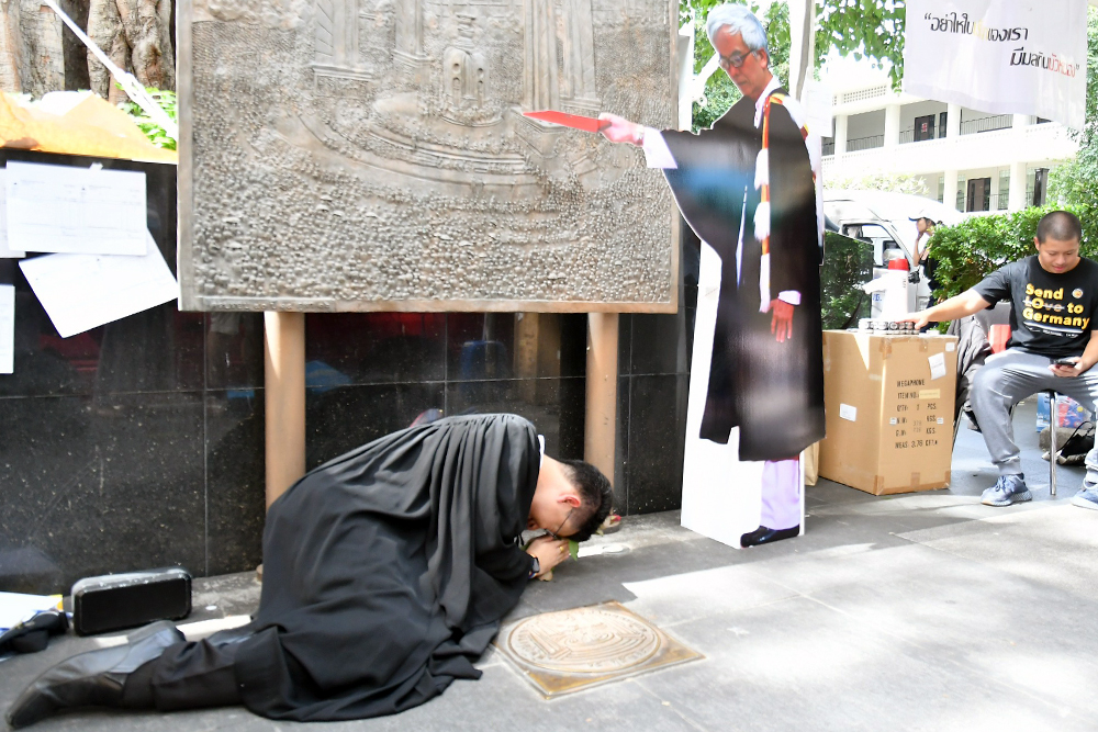 A Thammasat graduate kowtows before the cutout of Somsak Jeamteerasakul during the graduation ceremony at Thammasat University on Oct. 23, 2020.