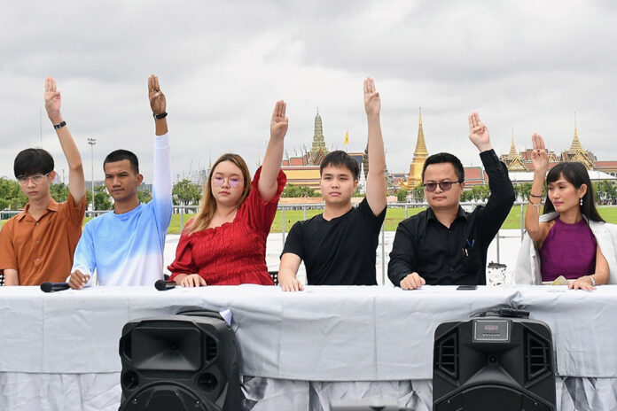 Panusaya Sithijirawattanakul, Tattep Ruangprapaikitseree, Arnon Nampa, and other activists flash the anti-military “three finger salute” at a news conference at Sanam Luang on Oct. 8, 2020.