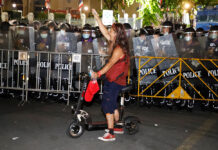 Opposition, Rights Watchdogs Slam Protest Emergency Decree A man raises a three-finger salute as riot police disperse protesters outside Government House on Oct. 15, 2020.