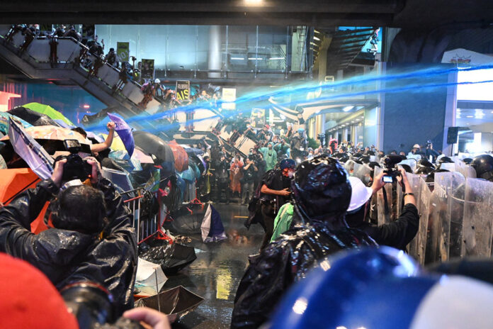 Police shoot water cannons laced with chemical irritants at protesters in front of Siam Paragon on Oct. 16, 2020.
