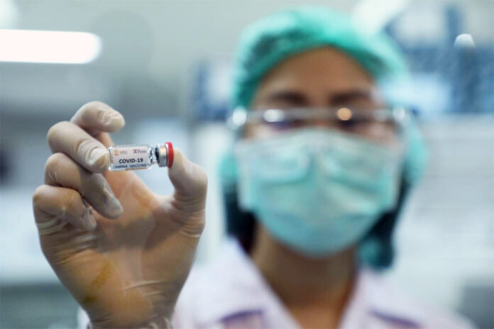 A researcher shows a vial of the prototype COVID-19 vaccine developed by Thai scientists.