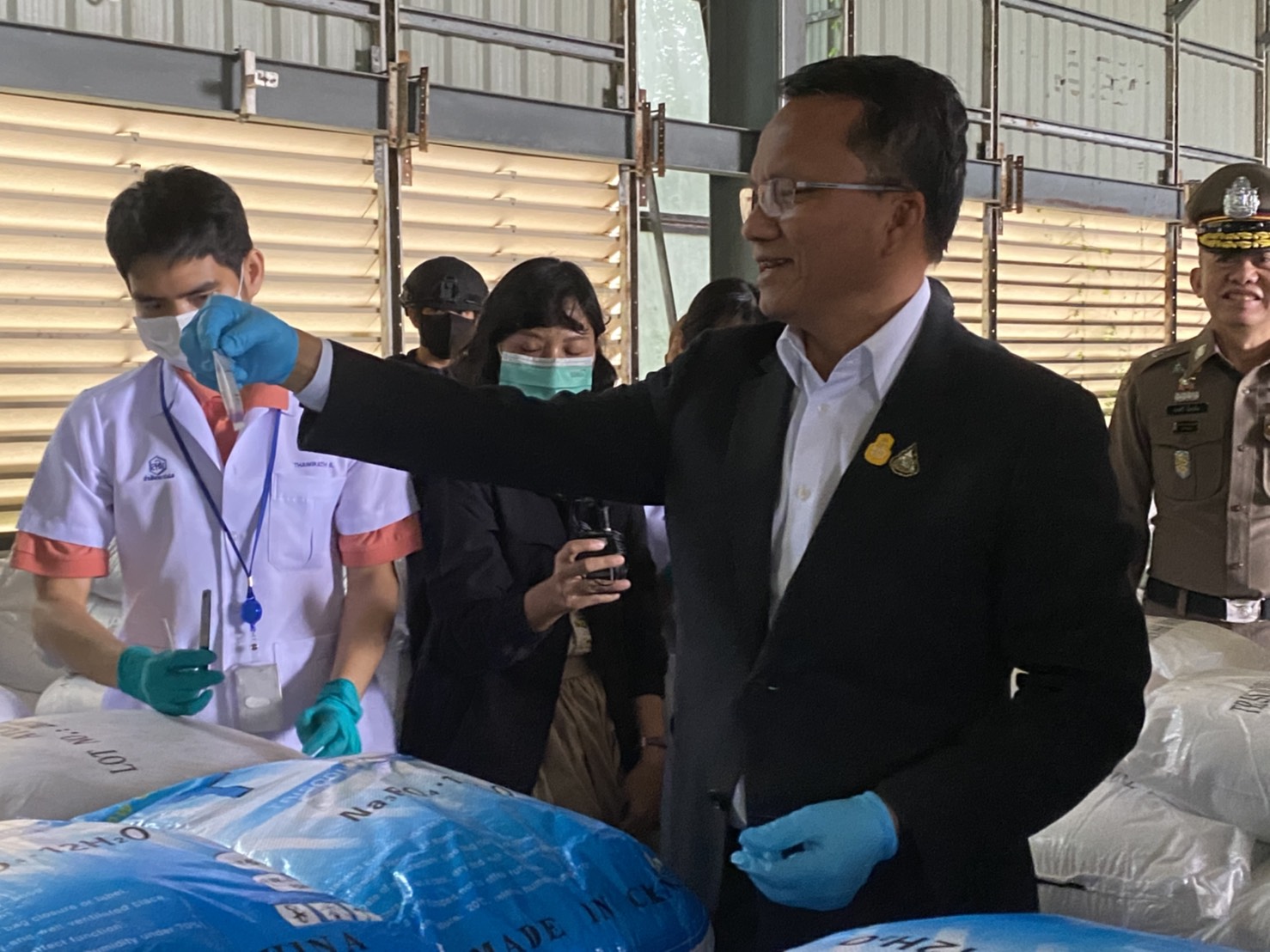 Justice minister Somsak Thepsuthin shows a test tube to members of the media.