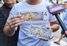 Activists Face Possible Charges for ‘Yellow Duck Banknotes’ A protester shows the mock banknotes at a protest in front of the Siam Commercial Bank’s headquarters on Nov. 25, 2020.
