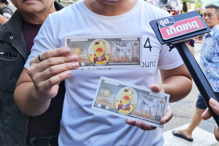 A protester shows the mock banknotes at a protest in front of the Siam Commercial Bank’s headquarters on Nov. 25, 2020. A protester shows the mock banknotes at a protest in front of the Siam Commercial Bank’s headquarters on Nov. 25, 2020.