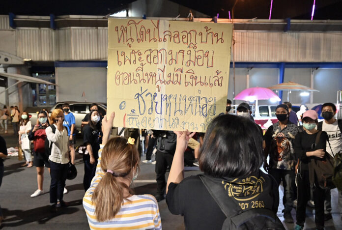 Two demonstrators hold up a placard at the protest on Nov. 27, 2020 on Friday saying that they have been disowned by their parents.