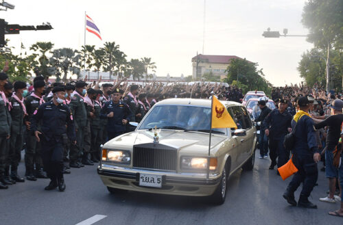 A royal motorcade drives through a crowd of anti-government protesters in front of Government House on Oct. 14, 2020.