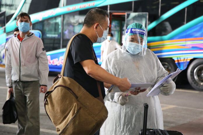 A health worker screens a foreign tourist arriving on the Special Tourist Visa scheme at Suvarnabhumi Airport on Oct. 26, 2020.