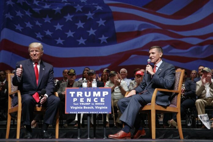 Then-presidential candidate Donald Trump gives a thumbs up as he speaks with retired Lt. Gen. Michael Flynn during a town hall, Tuesday, Sept. 6, 2016, in Virginia Beach, Va. (AP Photo/Evan Vucci, file)