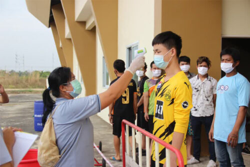 A migrant worker gets his body temperature checked at the provincial quarantine facility in Samut Prakan province on Dec. 24, 2020.