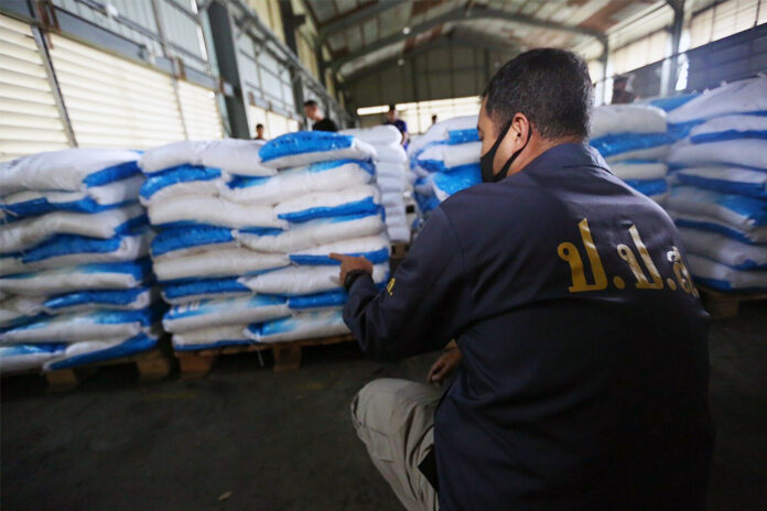 An agent from the Office of the Narcotics Control Board inspects piles of sacks believed to be containing ketamine during a raid of a warehouse in Chachoengsao province on Nov. 12, 2020.