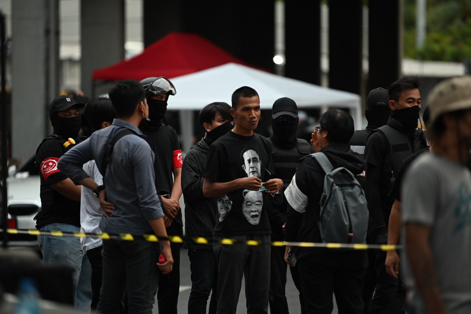 Protesters' security details stand guard next to protest leader Panupong “Mike” Jadnok at the protest on Dec. 2, 2020.