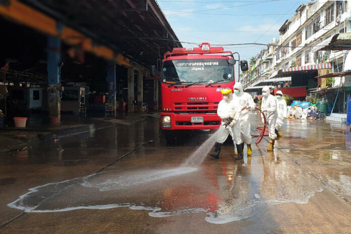 Workers disinfect a shrimp market in Samut Sakhon province on Dec. 18, 2020.