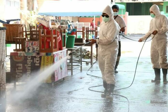 Health workers disinfect a fresh market in Nakhon Pathom province on Dec. 30, 2020.