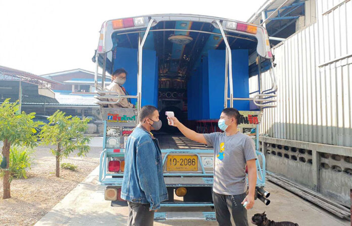 Anan Imjit checks the temperature of a passenger in Samut Sakhon city on Jan. 7, 2021.