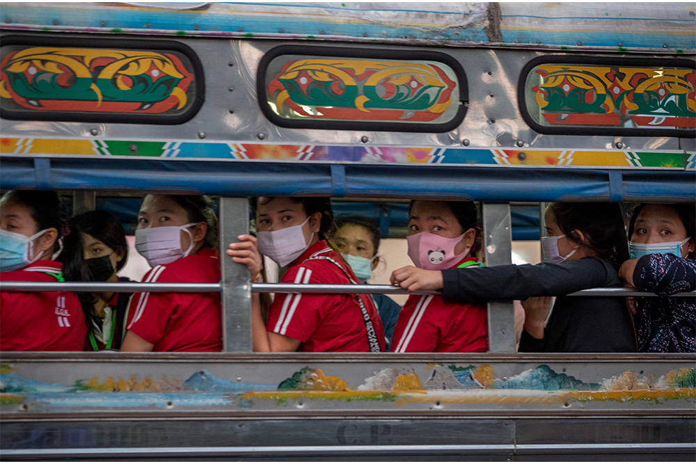 Migrant workers travel after work in the back of a truck in Samut Sakhon province on Jan. 4, 2021. Photo: Gemunu Amarasinghe / AP