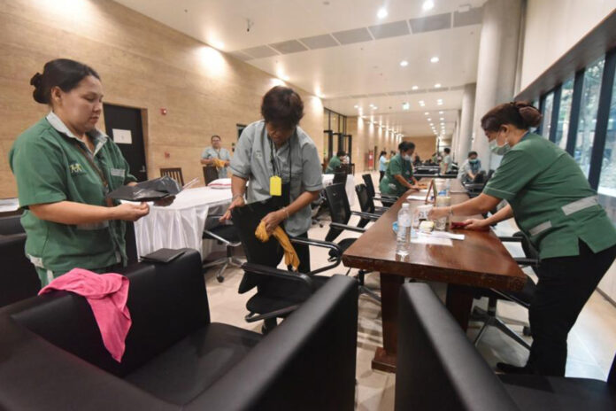 Workers disinfect reception area inside the Parliament building on Feb. 27, 2020.