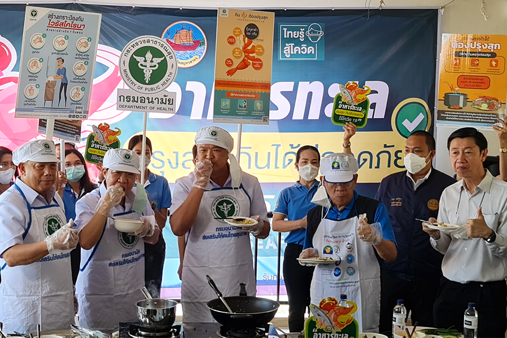 Samut Sakhon governor Veerasak Vijitsaengsri, wearing blue shirt, and health minister Anutin Charnvirakul, left to him, during a food safety event in Samut Sakhon province on Dec. 27, 2020.