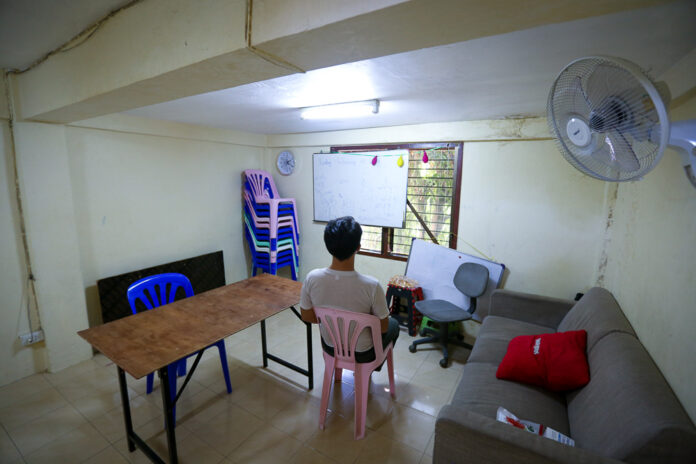 James sits in the living room, which regularly hosts English lessons for children in the community. James sits in the living room, which regularly hosts English lessons for children in the community.