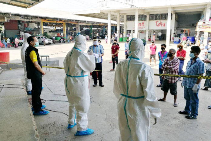 Health workers talk to migrant workers who are being quarantined at the field hospital inside the shrimp market in Samut Sakhon province on Dec. 25, 2020.