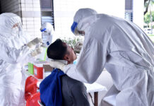 Immigration Backtracks on Plan to Require COVID-19 Test for Visa Extensions A file photo of a man taking a swab test for the coronavirus.