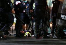 Beaten Medic Volunteer Charged With Breaking Emergency Decree Volunteer medic Purapon Wongchiak, 19, lies on the ground after he was beaten by police near Sanam Luang on Feb. 13, 2021. Photo: Reuters