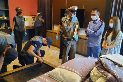 Somchai Jutikitdet, right, in blue shirt, during the police raid of his home in Rayong City on Feb. 11, 2021.