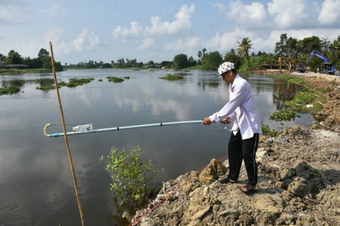 Suwat Kanjanawaha, 58, collects a water sample on Feb. 15, 2021 from Tha Chin River in Nakhon Pathom. Suwat, an orchid gardener, has had all his crops die since the river’s salinity reached levels as high as 4 grams per liter.