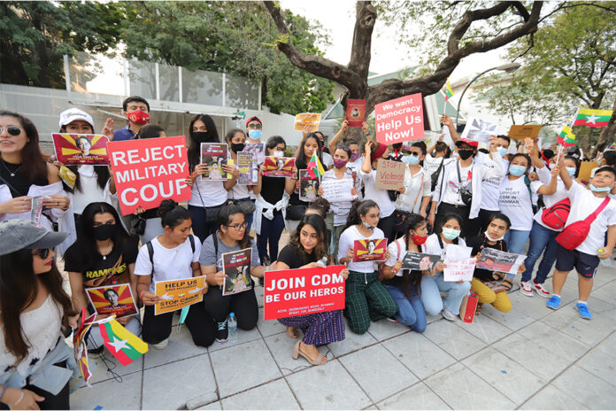 Burmese demonstrators hold up banners during an anti-coup protest in front of the United Nations office in Bangkok on Feb. 21, 2021.