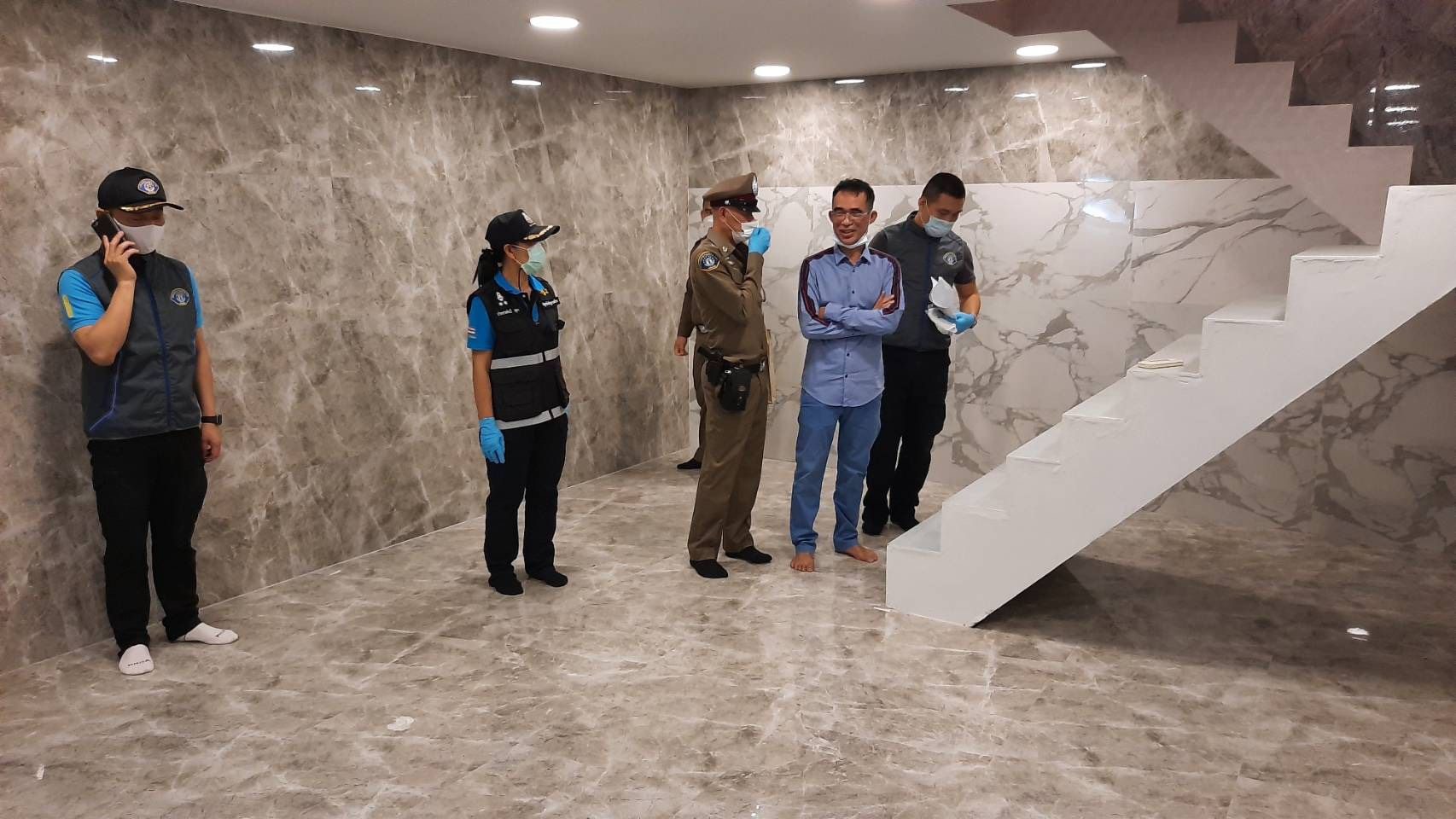 Police inspect an empty basement at Somchai's home.