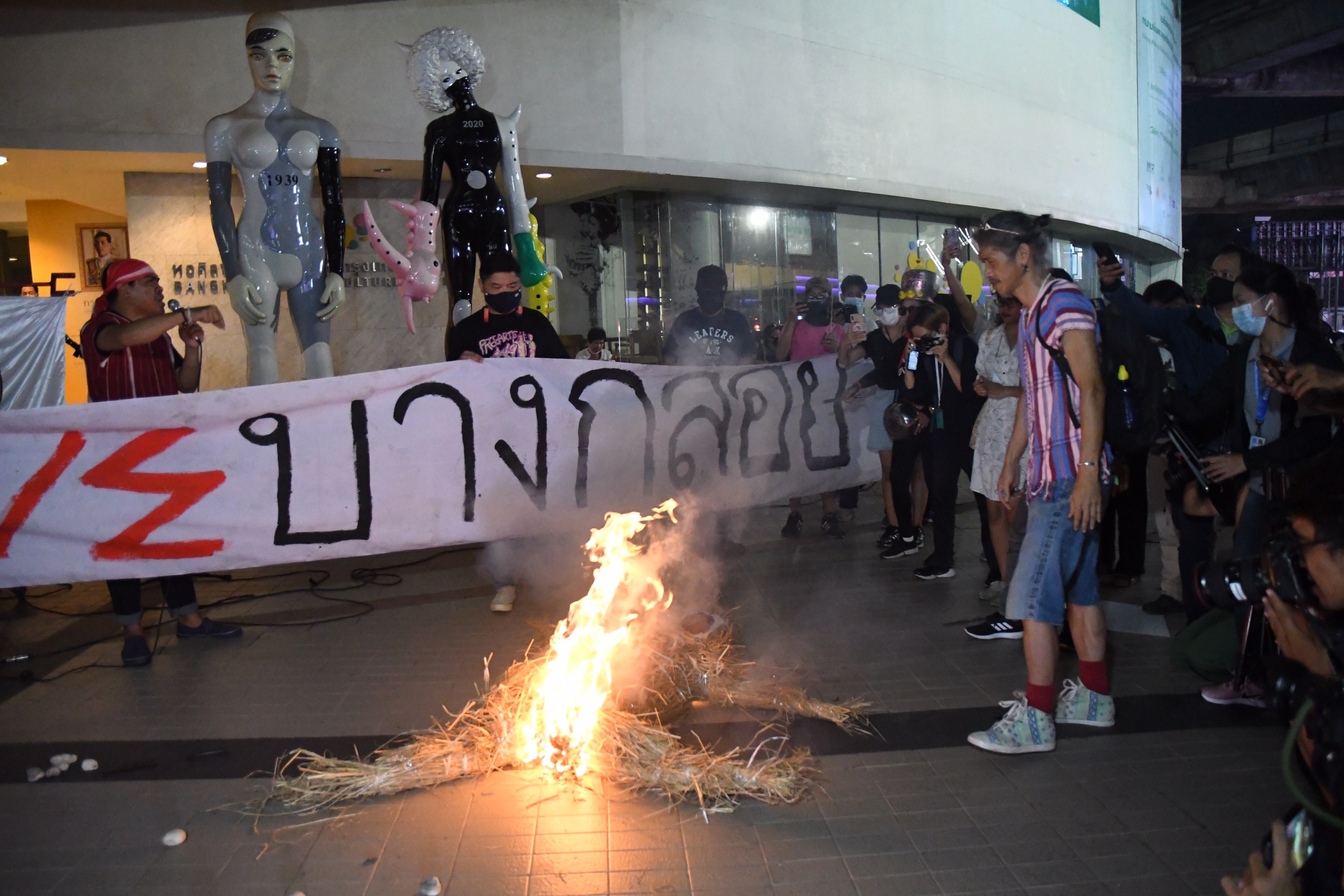 An activist sets fire to an effigy of environmental minister Varawut Silpa-archa during a protest in front of the Bangkok Arts and Cultural Center on Feb. 22, 2021.