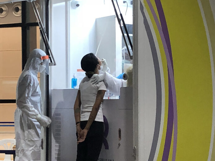 A woman destined for Thailand’s first “villa quarantine” gets a COVID-19 test on Feb. 21, 2021 at Phuket International Airport.