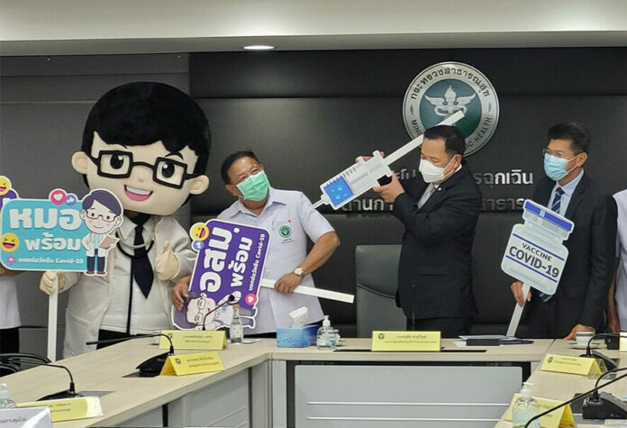 Health minister Anutin Charnvirakul holds a syringe prop during a press conference at the Ministry of Public Health on Feb. 25, 2021.