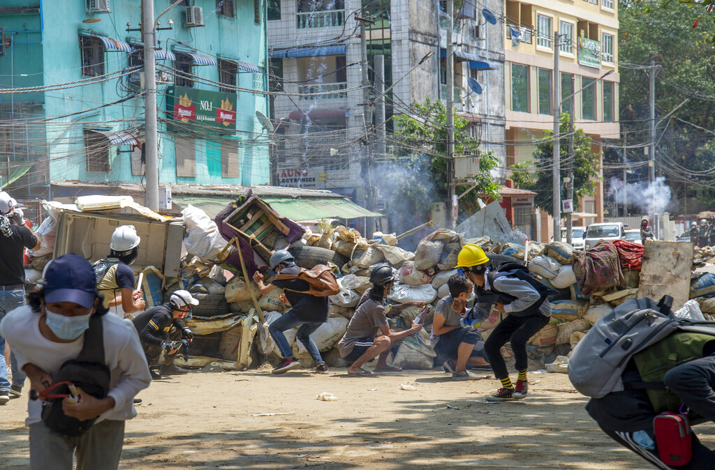 Policemen fire a charge as anti-coup protesters abandon their makeshift barricades and run in Yangon, Myanmar Tuesday, March 16, 2021. Photo: AP