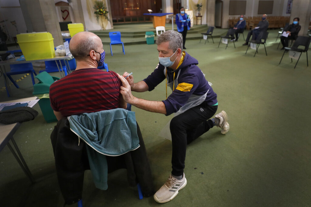 Nick Gray, a St Johns Ambulance vaccinator gives the AstraZeneca vaccine at St John's Church, in Ealing, London, Tuesday, March 16, 2021. Photo: Kirsty Wigglesworth / AP