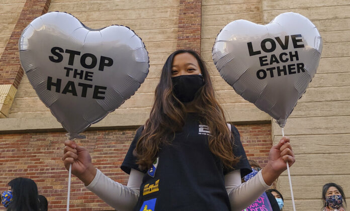 FILE - In this March 13, 2021, file photo, Chinese-Japanese American student Kara Chu, 18, holds a pair of heart balloons decorated by herself for the rally 