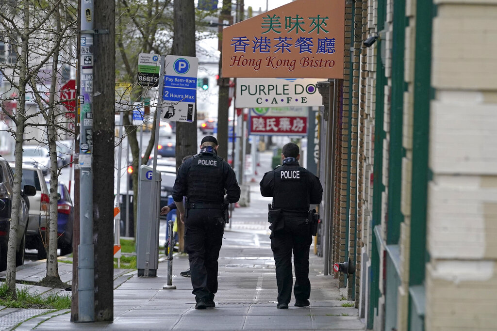 Two Seattle Police officers walk together after taking part in a public roll call at Hing Hay Park in the heart of Seattle's Chinatown-International District Thursday, March 18, 2021, at the start of their shift as part of a community response unit. Photo: Ted S. Warren / AP