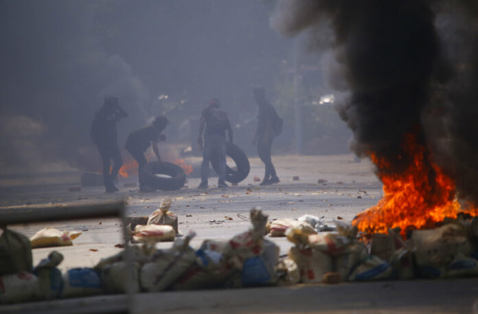 Protesters gather tires to add to the fires set during a rally against the military coup Saturday, March 27, 2021, in Tarmwe township in Yangon, Myanmar. Photo: AP