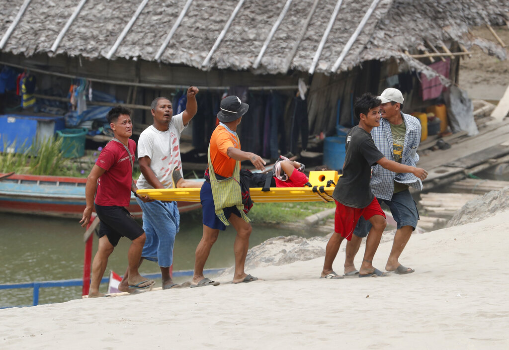 An injured Karenni villager from Myanmar is carried as they arrive via boat at Ban Mae Sam Laep Health Center, Mae Hong Son province, Thailand, Tuesday, March 30, 2021. Photo: Sakchai Lalit / AP