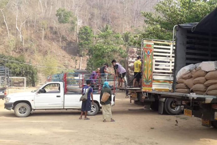 In this undated photo, a group of unidentified individuals load what appeared to be rice sacks to a truck at the Thai-Myanmar border in Mae Hong Son province.