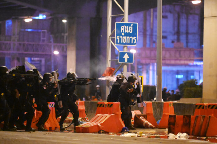 A riot police fires rubber bullet at anti-government demonstrators in front of the 1st Infantry Regiment army base on Feb. 28, 2021.