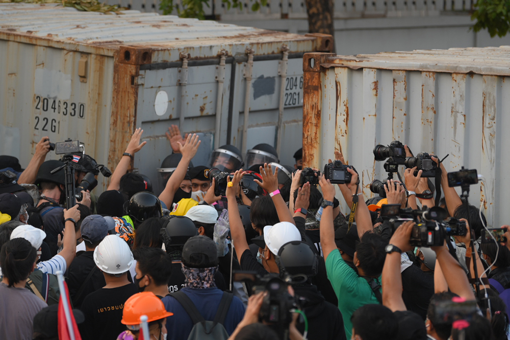 Photographers capture the moment when demonstrators clash with riot police in front of the 1st Infantry Regiment army base on Feb. 28, 2021.