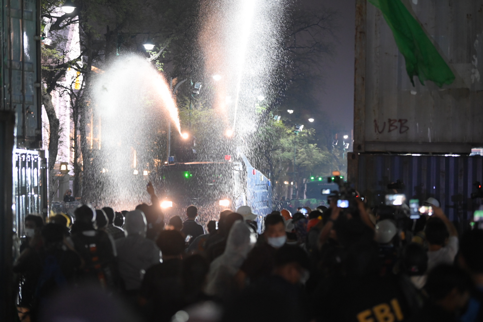 Police use water cannons to disperse protesters during the anti-government protest near the Grand Palace on Mar. 21, 2021.