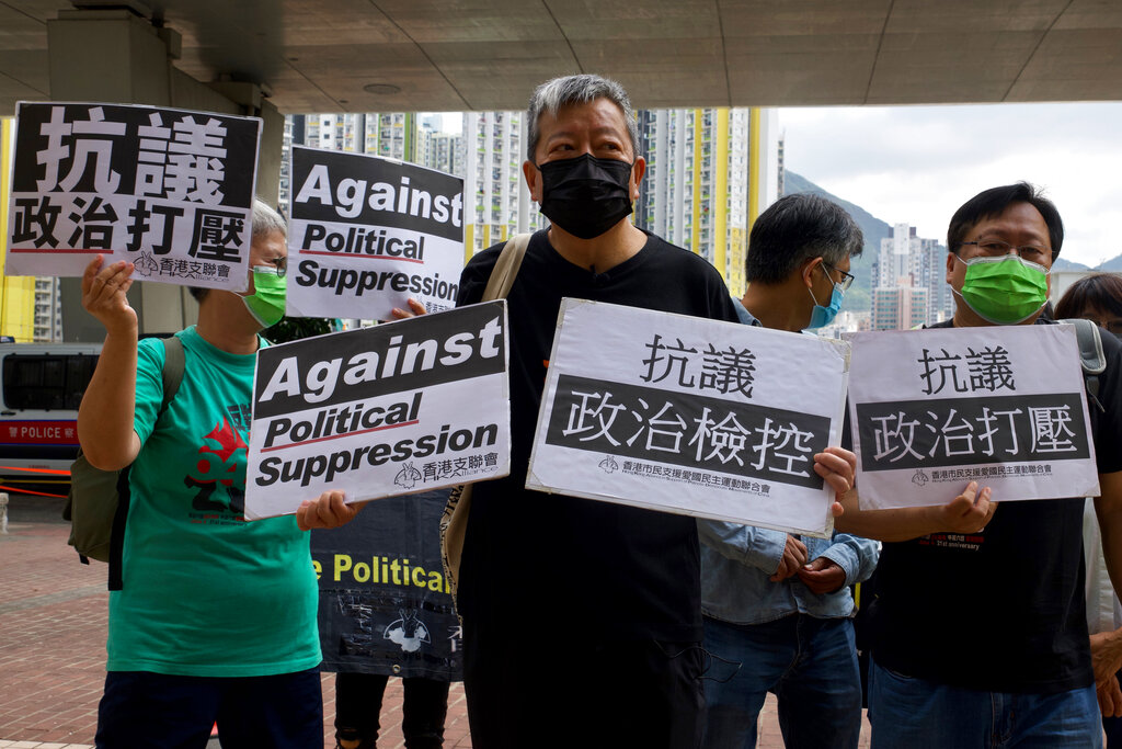 Pro-democracy activist Lee Cheuk-yan, center, holds placards as he arrives at a court in Hong Kong Thursday, April 1,2021. Photo: Vincent Yu / AP