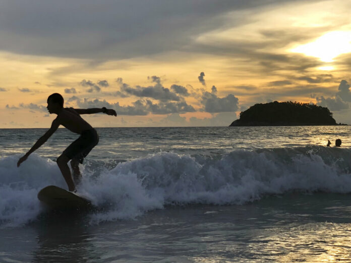 A surfer catches a wave as the sun sets over Kata Beach on the resort island of Phuket, Thailand on Sunday, May 26, 2019. Photo: Adam Schreck / AP A surfer catches a wave as the sun sets over Kata Beach on the resort island of Phuket, Thailand on Sunday, May 26, 2019. Photo: Adam Schreck / AP