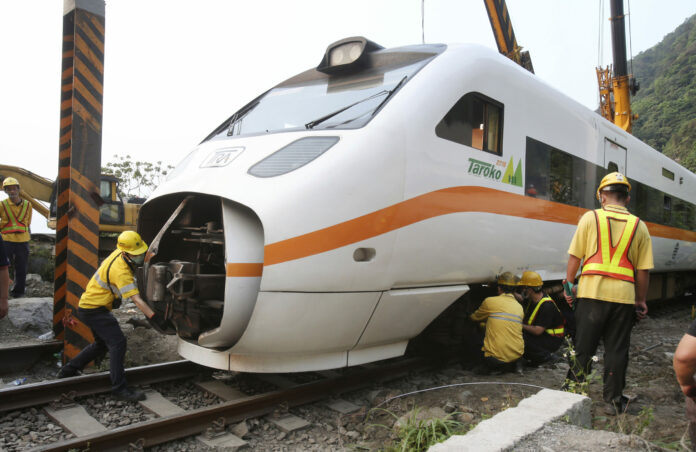 Rescue workers remove a part of the derailed train near Taroko Gorge in Hualien, Taiwan on Saturday, April 3, 2021. Photo: Chiang Ying-ying / AP
