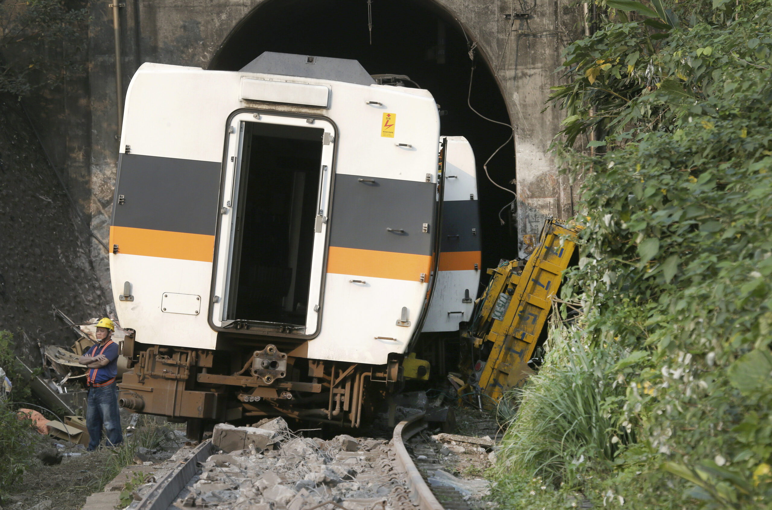 A worker stands in front of the derailed train near Taroko Gorge in Hualien, Taiwan on Saturday, April 3, 2021. Photo: Chiang Ying-ying / AP